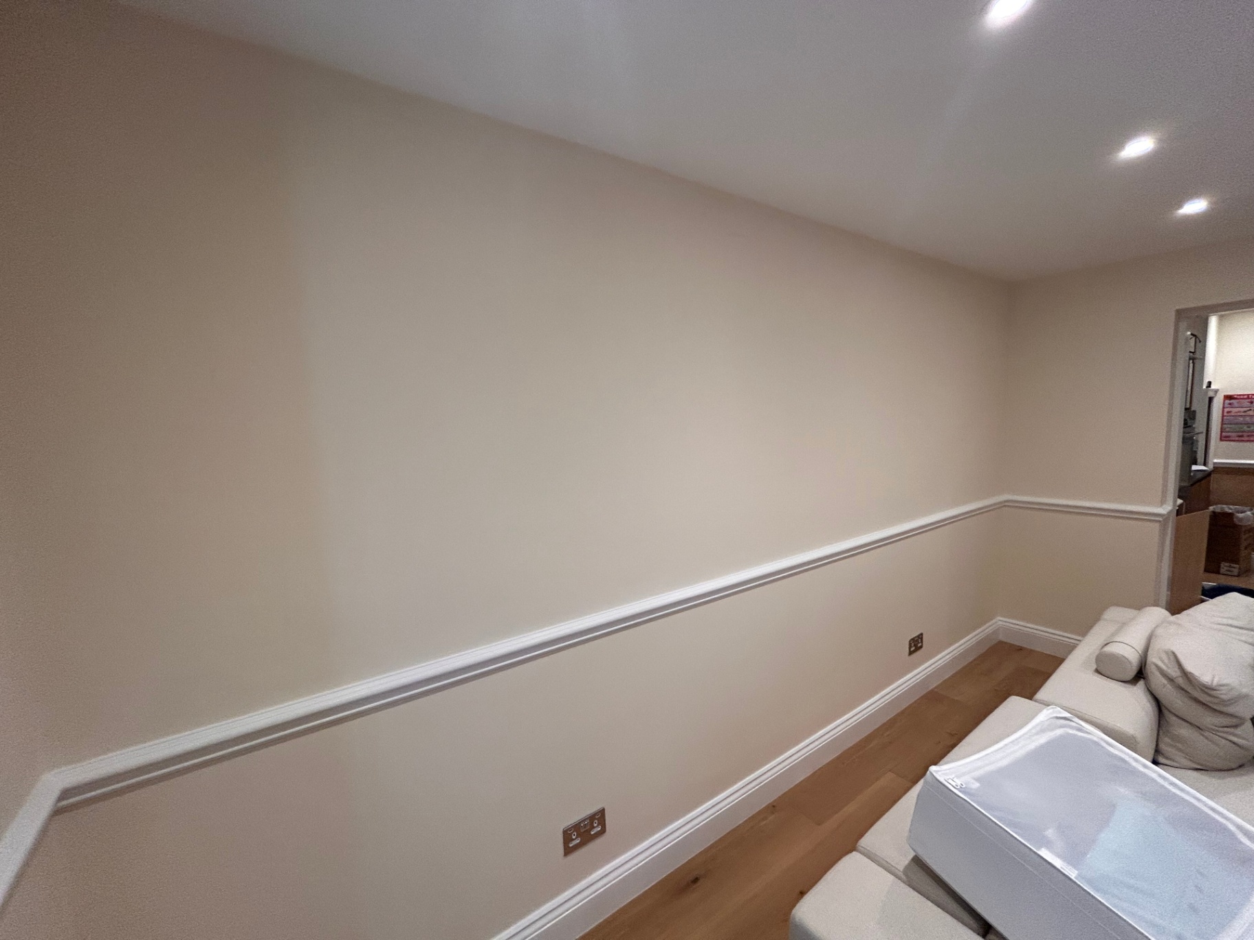 After photo — Belgravia garden-level room — full repaint in f&b tallow 203. Extensive filling and sanding of patched plaster, then two coats Farrow & Ball Tallow 203 emulsion matt with eggshell white woodwork and dado rail.