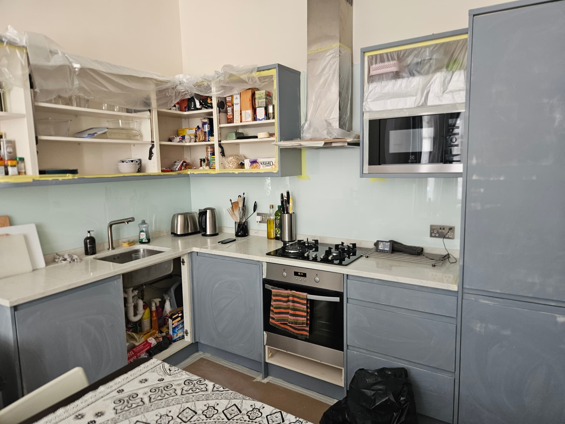 Before — Maida Vale kitchen transformation in farrow & ball treron. Preparation stage — trim taped, doors ready for degreasing and priming.